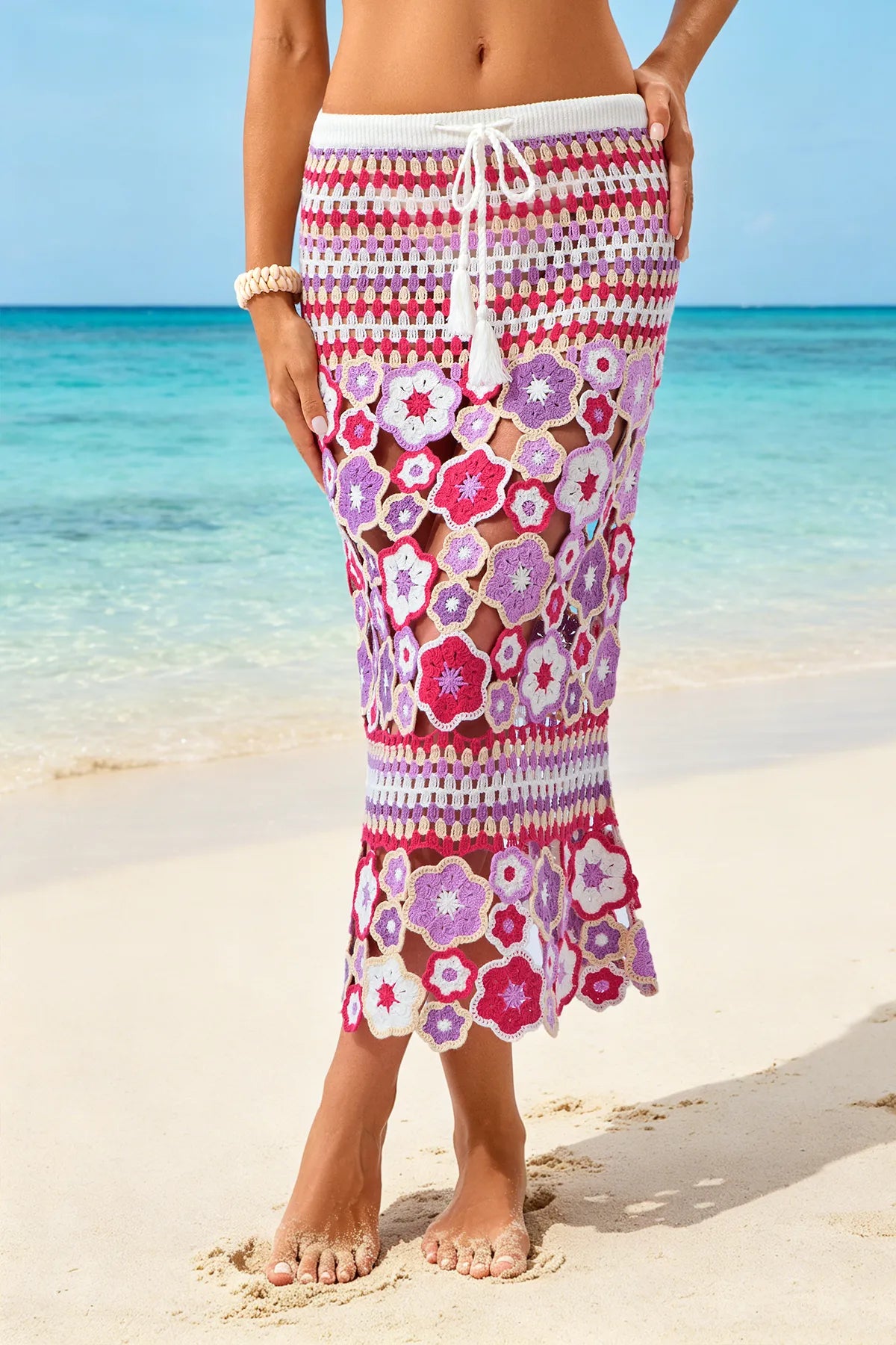 Person wearing a colorful floral skirt on a beach