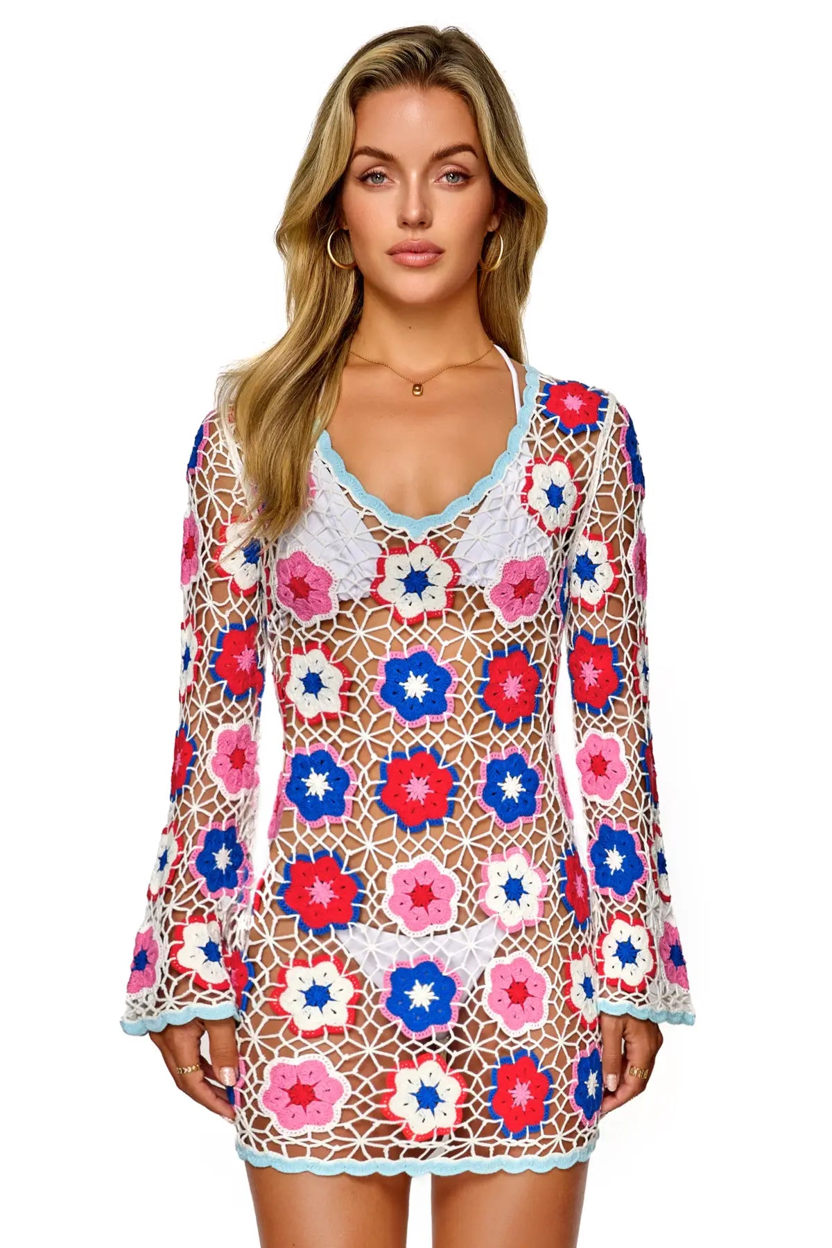 Woman wearing a colorful floral dress with long sleeves on a white background