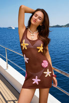 Woman in a brown mesh dress with starfish patterns on a boat deck with ocean view