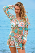Woman wearing a colorful crochet cover-up by the ocean