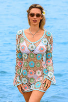 Woman wearing a colorful crochet cover-up by the water