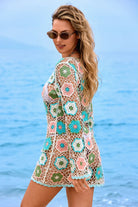 Woman wearing a colorful crochet cover-up by the ocean
