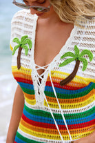 Colorful striped cover-up with palm tree designs on a beach.
