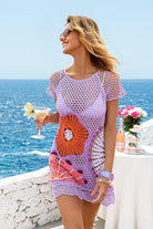 Woman in a colorful crochet dress by the ocean