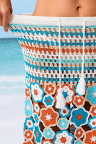 Close-up of a colorful floral-patterned bag with a beach background