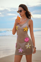 Woman in a crochet dress with starfish patterns on a beach