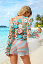 Woman in a colorful crochet cover-up on a beach
